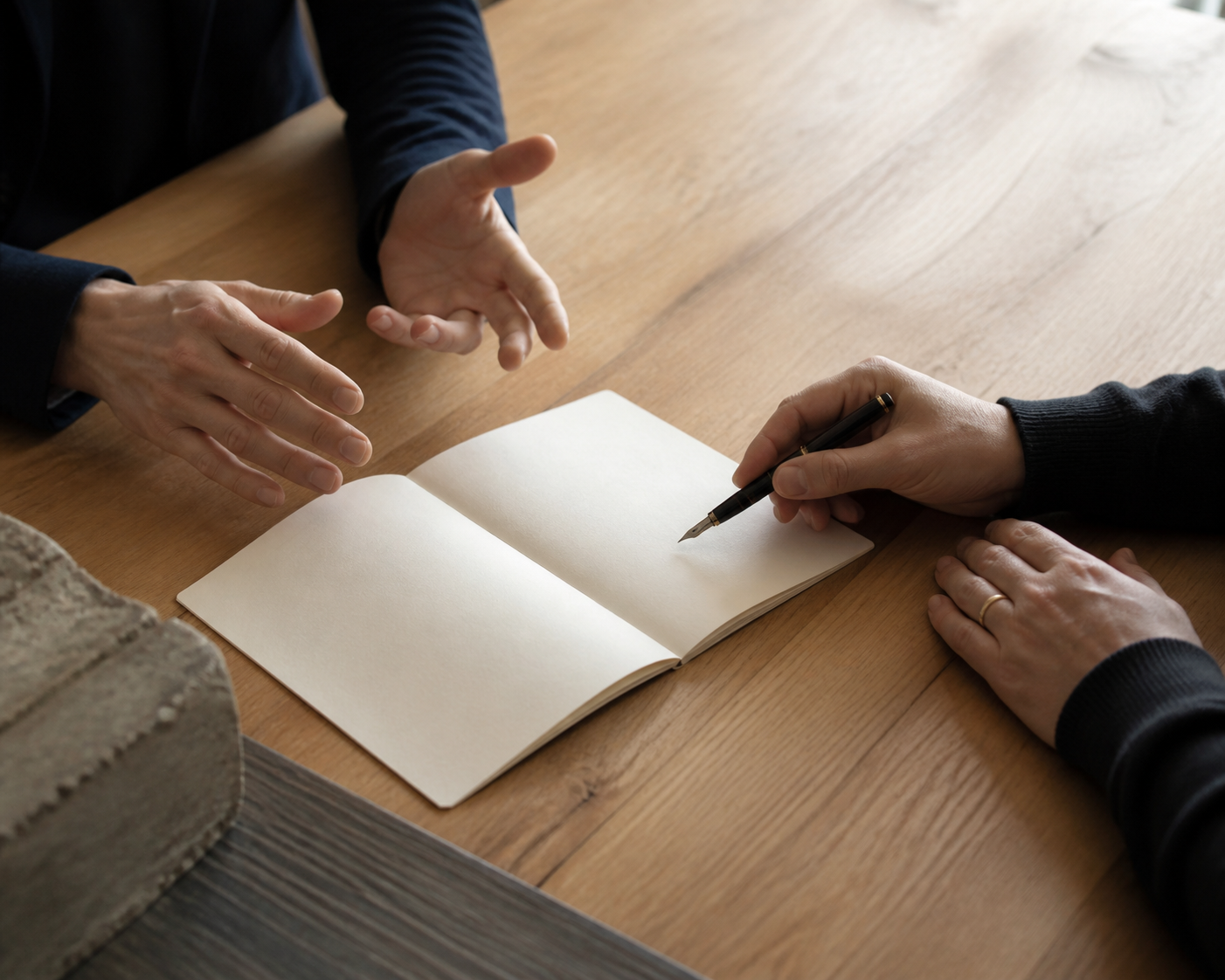A quiet professional conversation over an open notebook